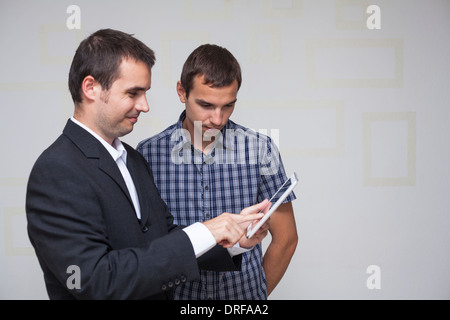 Two businessmen using digital tablet in the office. Stock Photo