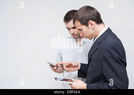 Two businessmen using digital tablet and smartphone. Stock Photo