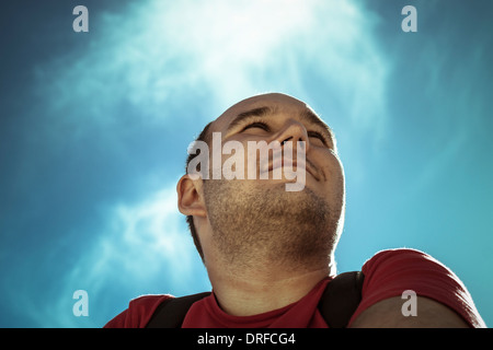 Pensive man thinking over bright blue sky Stock Photo