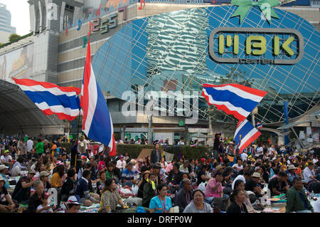 Bangkok, Thailand. Jan. 24th, 2014.  Anti-government protesters wave Thai National flags in front of the main stage by the upscale MBK shopping mall at the Pratunam intersection. after almost 3 months of protesting, there are still Tens of thousands of protesters on the streets of Bangkok demanding the resignation of Thai Prime Minister Yingluck Shinawatra. 'Shutdown Bangkok' is organized by the People's Democratic Reform Committee (PDRC). Credit: Kraig Lieb / Alamy Live News Stock Photo