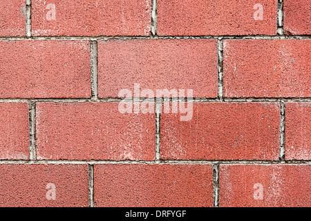 Modern red brick wall background with cracks in concrete Stock Photo