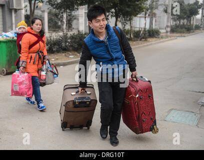 Anji, China's Zhejiang Province. 25th Jan, 2014. Shen Tianyong (1st R) and his wife, both working at Henglin Chair Industry, a local private company, take their 3-year-old son to board a chartered bus for home in Anji County, east China's Zhejiang Province, Jan. 25, 2014. Henglin chartered 20 buses to send its workers home for free for family reunion prior to the Spring Festival, which falls on Jan. 31 this year. © Xu Yu/Xinhua/Alamy Live News Stock Photo