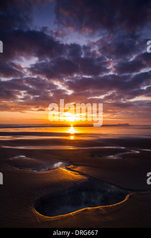 A view at sunrise in late summer from Bamburgh beach in Northumberland looking towards the Farne Islands Stock Photo