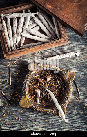 Cigarettes in old wooden box, ashtray and lighter Stock Photo