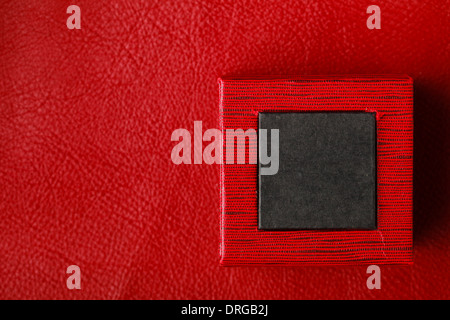 Red black rectangular ring jewellery box on leather background Stock Photo