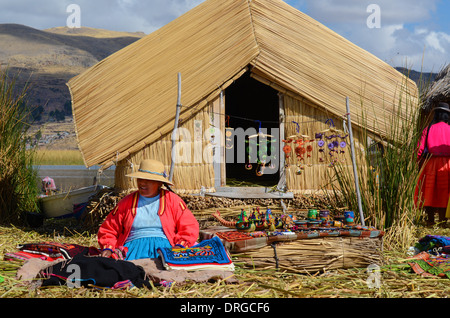 LAKE TITICACA, PERU - AUGUST 3: Uros Indian woman peddling her wares on a reed island in Lake Titicaca August 3, 2013. Stock Photo