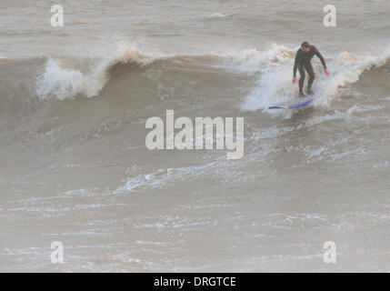 Hastings, East Sussex, UK. 26th Jan, 2014. Surfer in the waves off Hastings Old Town Beach as wet and windy weather returns to the UK. Credit:  David Burr/Alamy Live News Stock Photo