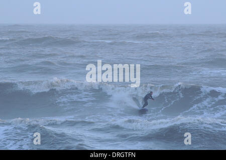 Hastings, East Sussex, UK. 26th Jan, 2014. Surfer in the waves off Hastings Old Town Beach as wet and windy weather returns to the UK. Credit:  David Burr/Alamy Live News Stock Photo