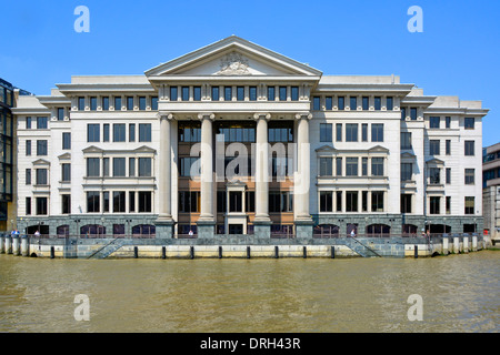 The classical granite and limestone riverside facade of the Vintners Place office building beside high tide River Thames in the City of London Stock Photo