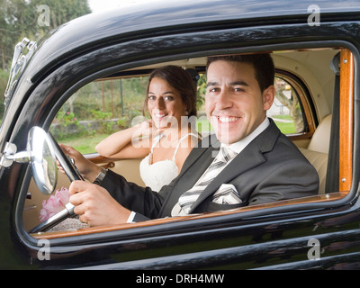 Married couple in a old car. They are looking at camera. Stock Photo