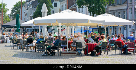 Maastricht City shopping & tourist customers at busy cafe pavement bar restaurant in street scene hot July summers day in urban landscape Netherlands Stock Photo