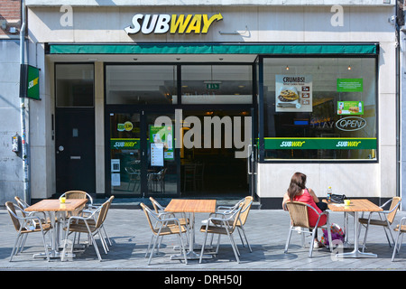 Maastricht City back view woman sitting at pavement table outside a Subway sandwich shop business sunny July summer day in Limburg Netherlands Europe Stock Photo