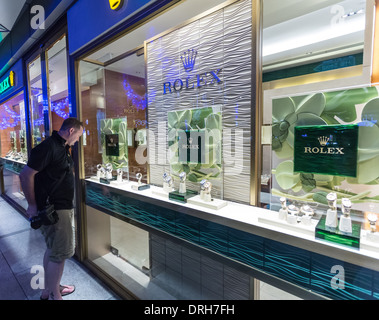 Man looks at expensive rolex watches in shop window Stock Photo