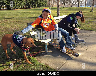 Seattle, Washington, USA. 26th Jan, 2014. Denver Broncos fan HENRY BI, left, in a Peyton Manning jersey, and Seattle Seahawks fan ANDREA COWAN, in a Richard Sherman jersey, prepare for a skate around Green Lake. Even their dog, Red, was wearing a Seahawks jersey. The couple joked that their house is divided. Bi said he'll attend the Super Bowl in New Jersey next Sunday. © � Cheryl Hatch/ZUMA Wire/ZUMAPRESS.com/Alamy Live News Stock Photo