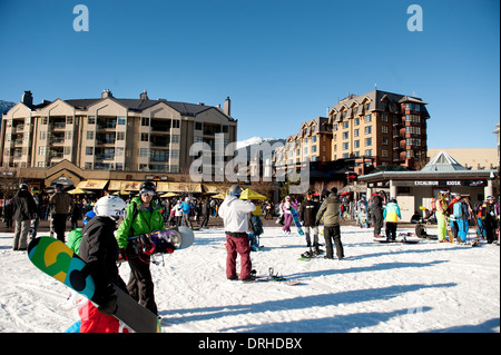 Whistler village in the winter skiers and snowboarders.  Whistler BC, Canada Stock Photo