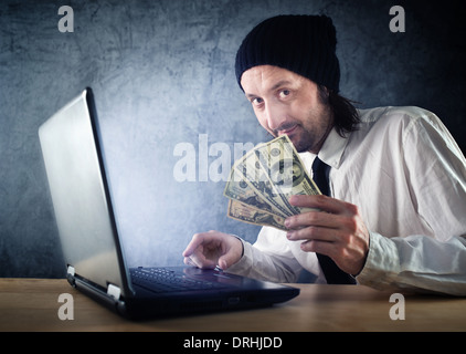 Making money online, businessman with laptop computer is earning money over internet. Stock Photo
