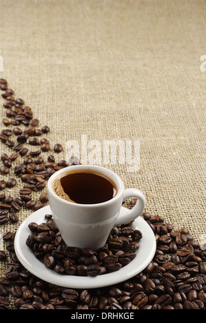 Background with cup of coffee and coffee beans on round fabric Stock Photo