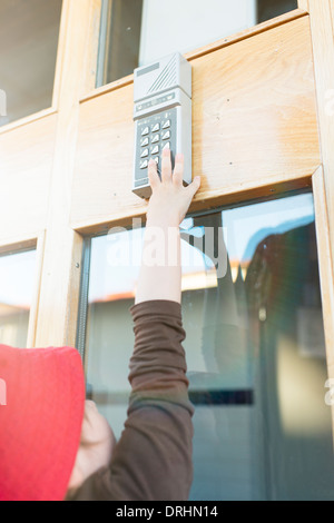 Young child reching for entrance  code box, pressing the buttons Stock Photo