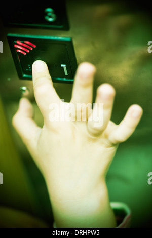 Hand of child pressing button in elevator, ominous and scary mood. Stock Photo