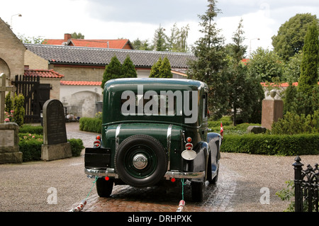 Old car is driving the wedding couple away.l Stock Photo