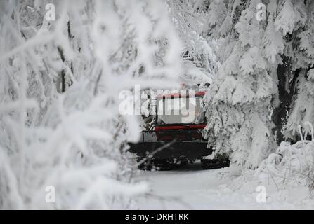 the Hoher Meissner mountain, Germany. 27th Jan, 2014. A snowplough makes it's way through the trees on a snow white path on the Hoher Meissner mountain, Germany, 27 January 2014. More snow and sub-zero temperatures are forecast for the region according to weather reports. Photo: UWE ZUCCHI/dpa/Alamy Live News Stock Photo