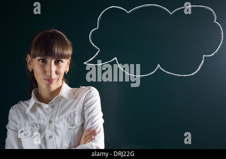 Beautiful girl with sketch thought bubble speech balloon at chalkboard black background Stock Photo
