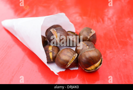 Roasted sweet chestnuts in a paper cone - shallow depth of field Stock Photo