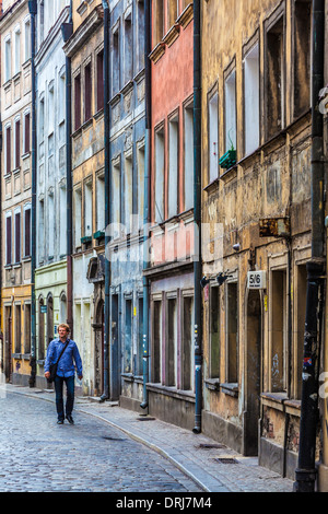 A young man walks along a narrow, cobbled sidestreet in Wroclaw's old town. Stock Photo