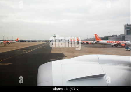 View of Gatwick Airport North terminal showing row of parked Easyjet aircraft plane. Stock Photo