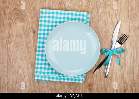 Fork with knife, blank plates and napkin. On wooden table background Stock Photo