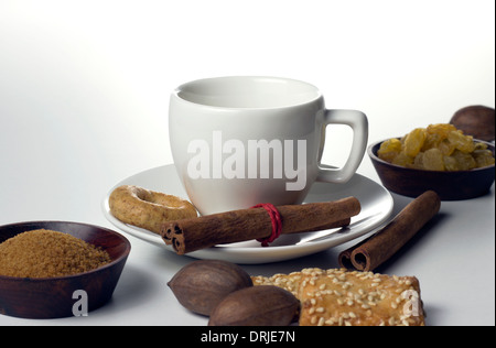 coffee cup with biscuits sugar nuts and raisin on white table Stock Photo