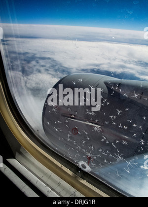 Window frost "ice flowers" form on an airplane window at high altitude when the glass pane is exposed to very cold air. Stock Photo