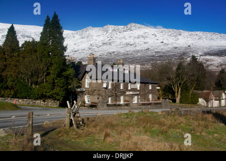 Penygwryd or Pen-y-Gwryd Hotel with snow-capped mountains behind Snowdonia National Park Gwynedd North Wales UK Stock Photo