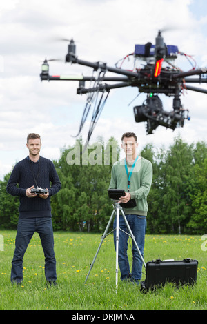 Technicians Flying UAV Helicopter in Park Stock Photo