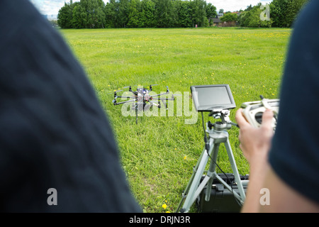 Technicians Operating UAV Helicopter in Park Stock Photo