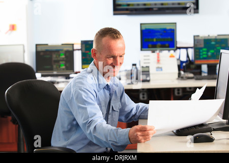Electrical engineer in central operating command room at power station Stock Photo
