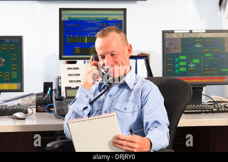 Electrical engineer in central operating command room at power station talking on phone Stock Photo