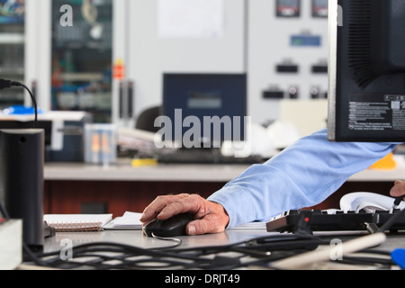 Electrical engineer using computer mouse while monitoring operations at a power plant Stock Photo