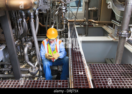 Engineer working on gas turbine which drives generators in power plant while turbine is powered down Stock Photo