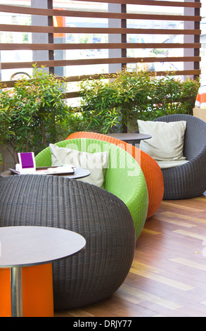 Colorful modern weaved oval chairs with tables. Stock Photo