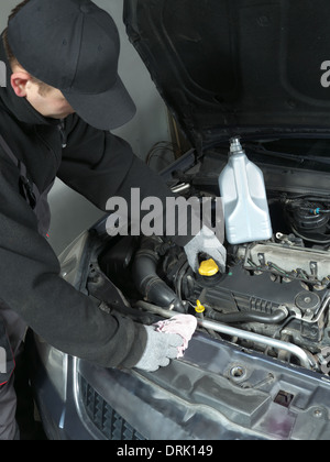 Auto mechanic unscrewing oil filler cap Stock Photo