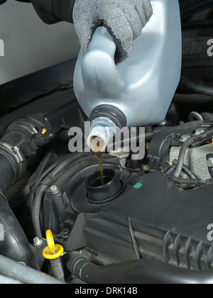 Auto mechanic replenishing engine oil Stock Photo