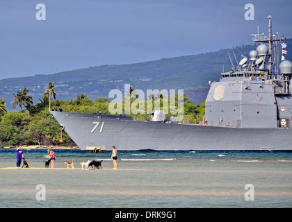 US Navy guided missile cruiser USS Cape St George transits the waters of Pearl Harbor past bathers January 25, 2014 in Honolulu, HI. Stock Photo