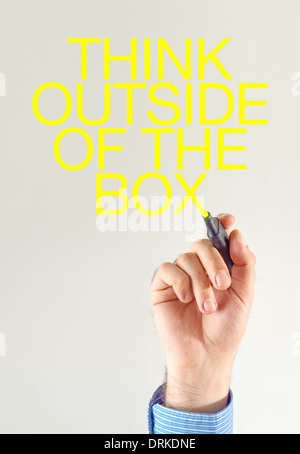 Think outside of the box. Businessman writing with yellow marker pen on the screen Stock Photo