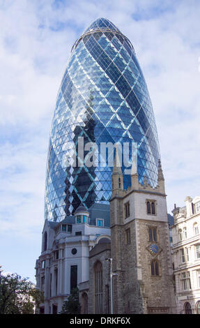 The Gherkin, popularly THE CUCUMBER (GHERKIN) called 30 St Mary Axe, front Saint Andrew Undershaft Church of England, London, United Kingdom - 2013. Stock Photo