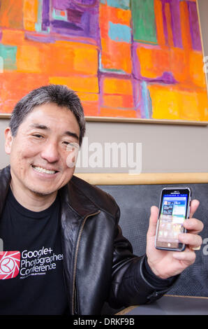 Apple fans know Guy Kawasaki as former chief evangelist for the Macintosh computer maker. Now Kawasaki works as consultant to Google's mobile handset unit Motorola. At a cafe in Menlo Park, he shows his Android smartphone. - 2013. Stock Photo