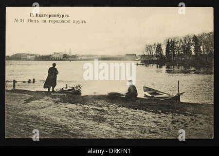 The City Pond (Gorodskoy Pond) on the Iser River in Yekaterinburg, Russian Empire. Black and white vintage photograph by Russian photographer Veniamin Metenkov dated from the beginning of the 20th century issued in the Russian vintage postcard published by Veniamin Metenkov himself in Yekaterinburg. Text in Russian: Yekaterinburg. View of the City Pond. The Iset River forms the City Pond (Gorodskoy Pond) in the city centre of Yekaterinburg. Courtesy of the Azoor Postcard Collection. Stock Photo