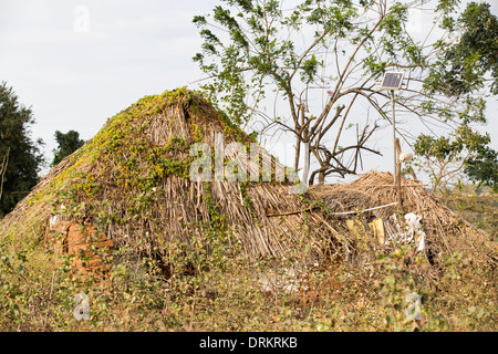 An untouchable familes hut, illuminated by an electric light, powered by an A4 sized solar panel, that charges a battery, Stock Photo