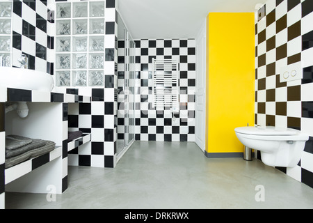 Modern bathroom with checkered black and white tiles on walls. Stock Photo