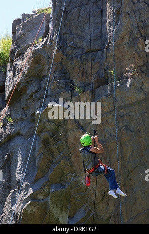 Man with spinal cord injury using adaptive climbing equipment for rock climbing Stock Photo